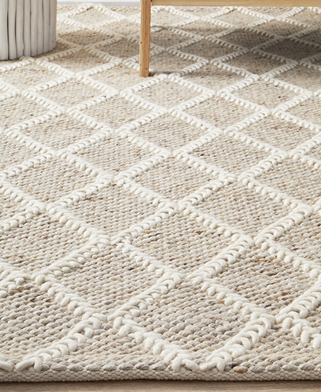 Pictured from one side, the rug's plaited diamond pattern is highlighted.