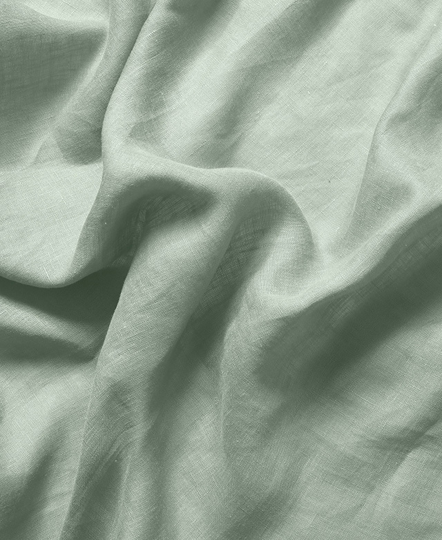 Close-up of the sage French flax linen sheets illustrates the woven fibres of the natural textile.