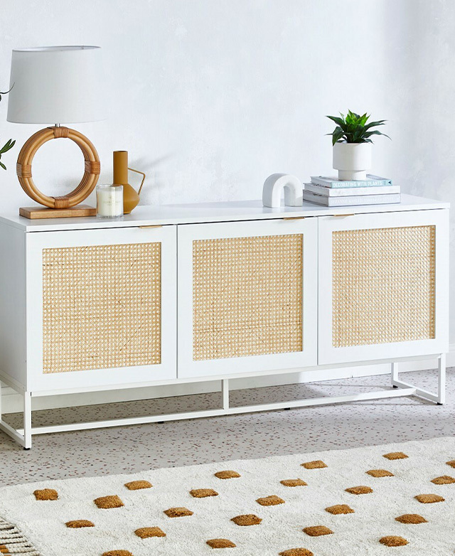 Tones of white and amber thread through this image of the sideboard. The rattan panels contrast against the white frame.