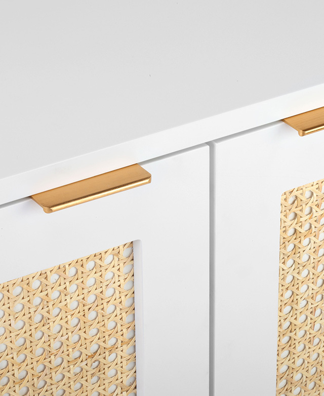 Golden stainless steel flat handles of the white iteration are zoomed in on.