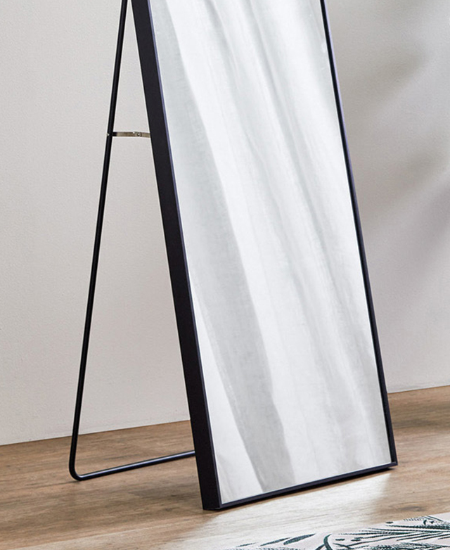 The base of a minimalist arch mirror, with a stand attached at the back for easy and versatile positioning.