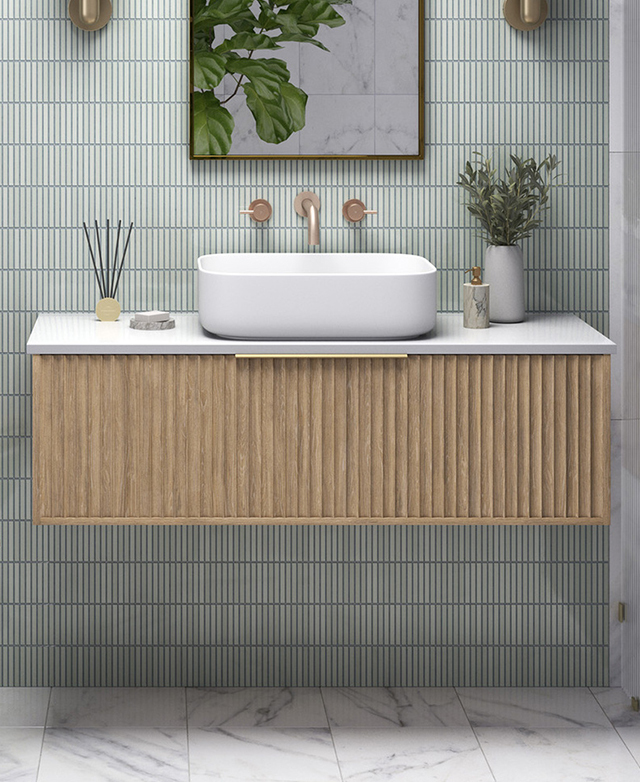The rectangular white and timber vanity is mounted on a green, finger tile feature wall in a bathroom interior.