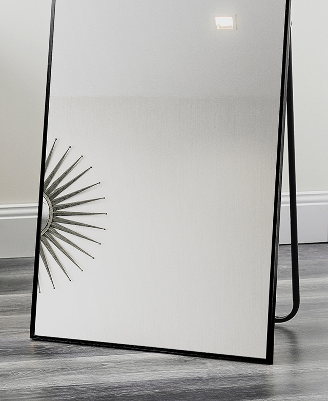The base of a mirror with a slender black frame, and a stand attached to the back for easy positioning.