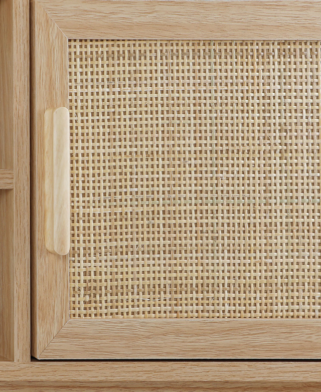 The smooth, narrow frame of the cupboard door - complete with handle - juxtaposes a woven rattan panel, close up.