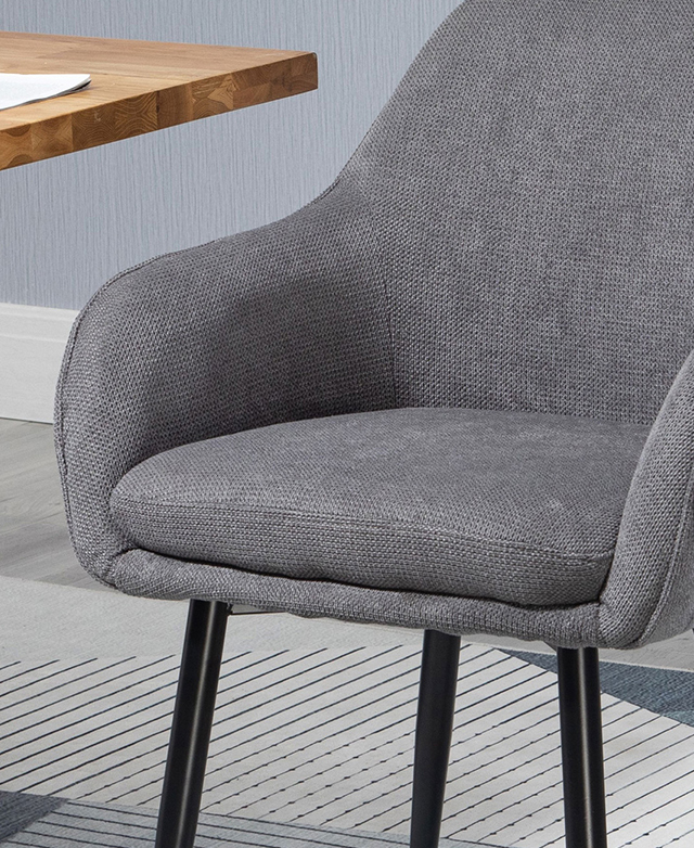 The charcoal iteration of the dining chair is pictured next to a just-seen dining table.