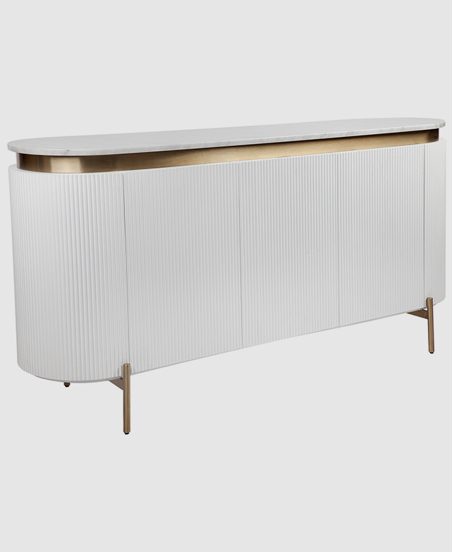 Full view of an oval-shaped buffet. A brass plinth sits between the marble top and the white fluted MDF body.