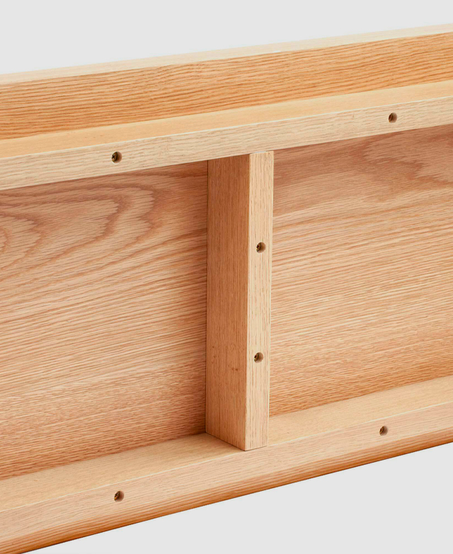 View from underneath a bench seat with holes pre-drilled into the frame to attach the legs.