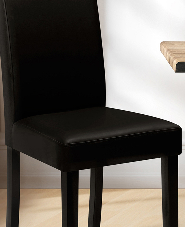 Cropped view of a black minimalist dining chair with polyurethane leather upholstery in a bright room. Cropped view of a black minimalist dining chair with polyurethane leather upholstery in a bright room.