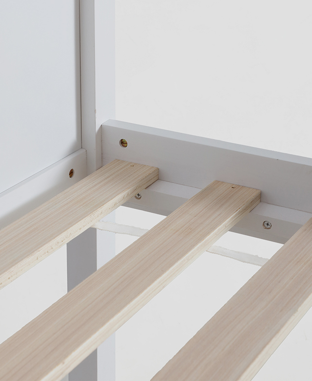 Close view of a slatted base and the white bed frame it sits within. Close view of a slatted base and the white bed frame it sits within.