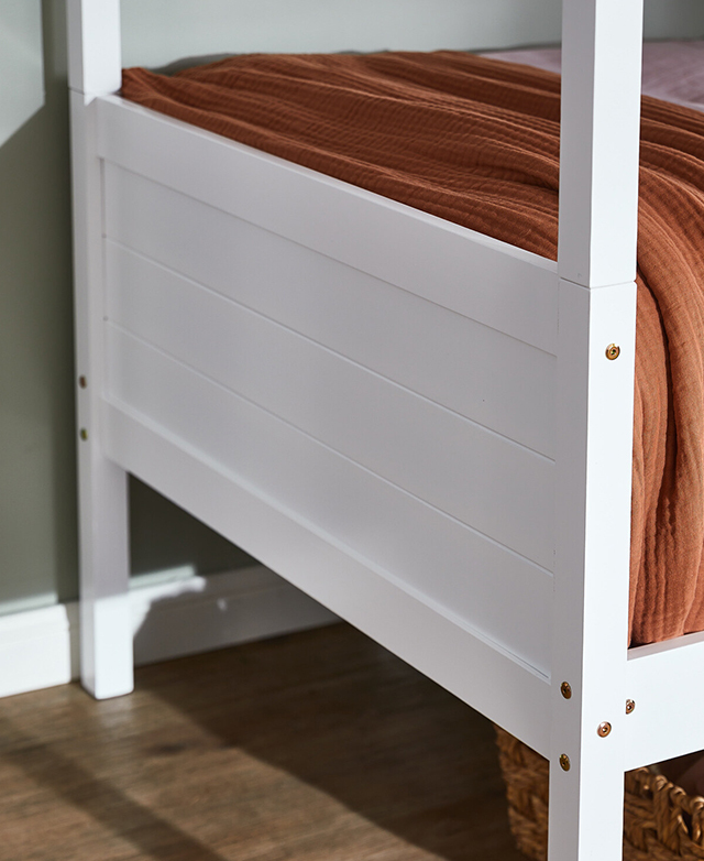 Close view of an external footend with subtle coastal-style panelling, and a terracotta throw on the bed. Close view of an external footend with subtle coastal-style panelling, and a terracotta throw on the bed.