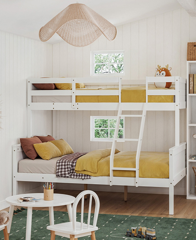 Ochre and brown bedding dresses the fully-assembled white bunk bed, which is next to a green rug in a bright room. Ochre and brown bedding dresses the fully-assembled white bunk bed, which is next to a green rug in a bright room.