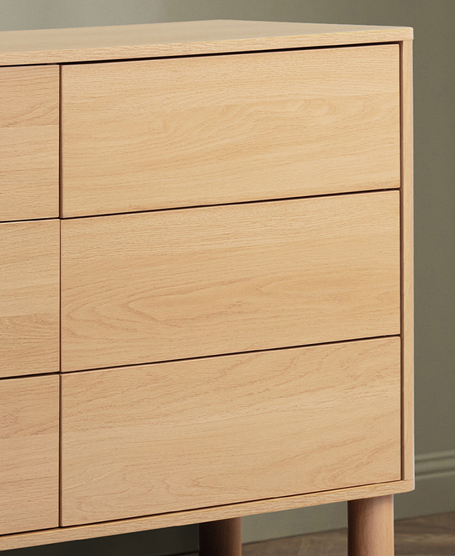 The laminated surfaces of the chest of drawers have the appearance of wood with sweeping grain patterns. The laminated surfaces of the chest of drawers have the appearance of wood with sweeping grain patterns.