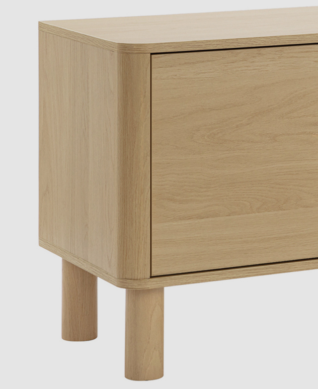 One end of the entertainment unit is highlighted to show its rounded corners and thick cylindrical legs. One end of the entertainment unit is highlighted to show its rounded corners and thick cylindrical legs.