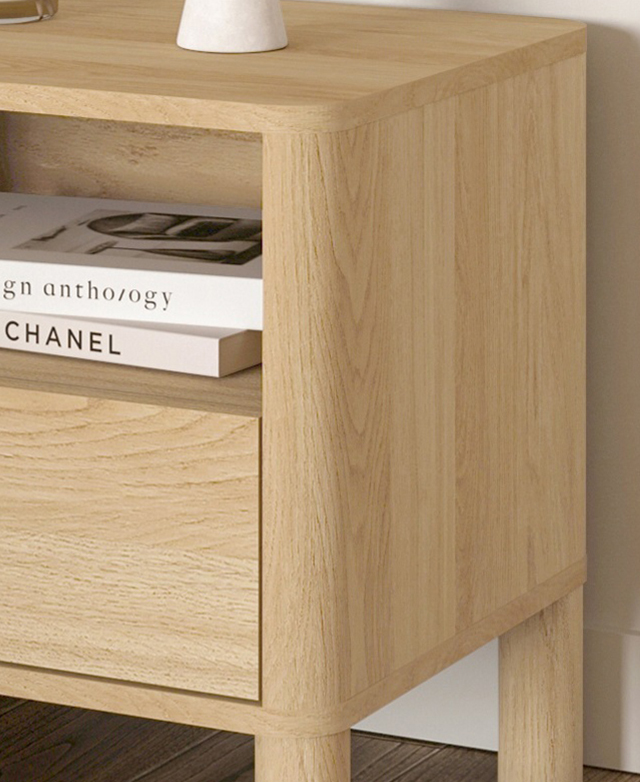 A three-quarter angled image displays the table's rounded corners while showing a stack of books in the open shelf A three-quarter angled image displays the table's rounded corners while showing a stack of books in the open shelf