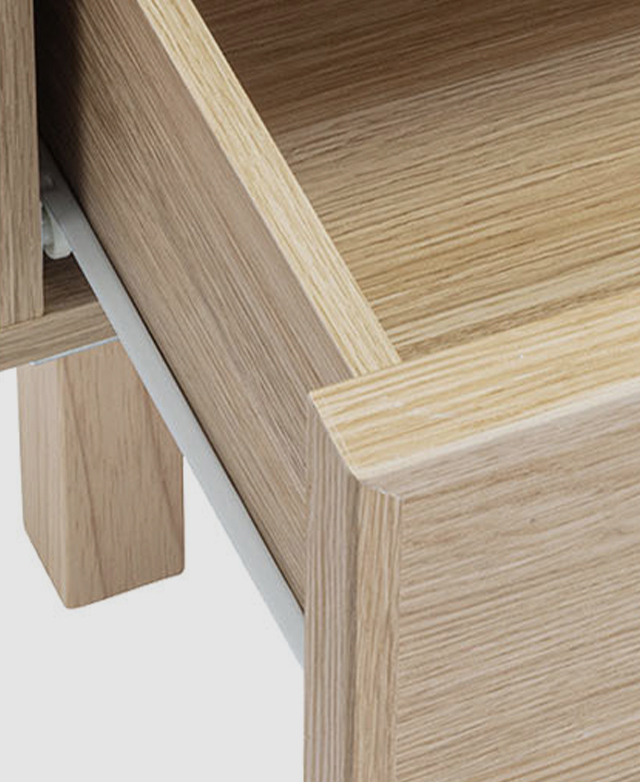 Bird's-eye view of a single drawer partially open shows a white metal runner.
