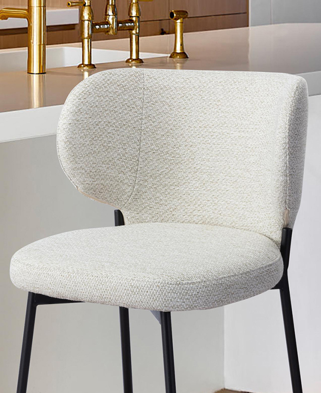 Bar stool is in front of a kitchen counter, with the focus on the upholstered seat.