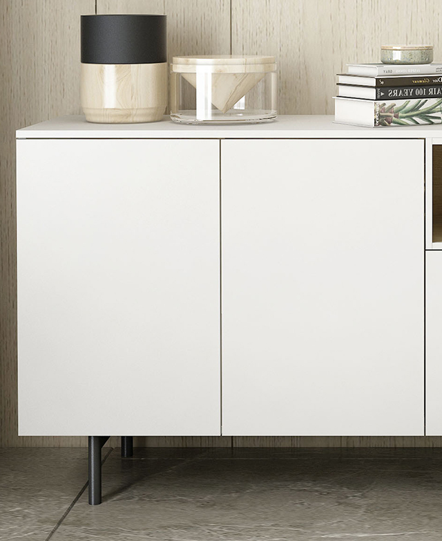 Books and decorative objects adorn the white buffet, which is shown in a bright room on a tiled floor.