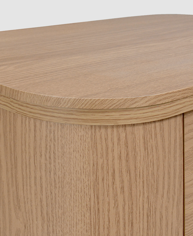 Close view of the bedside table highlights a smooth, deeply-rounded corner.