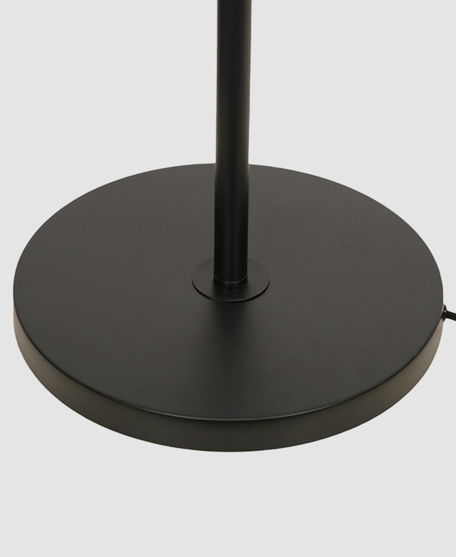 The simple, round black lamp stand is shown against a white background.