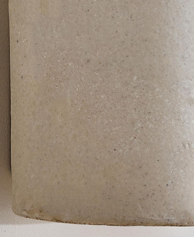 Cropped view of the cast stone wall light material, which features subtle speckling and shades of grey.