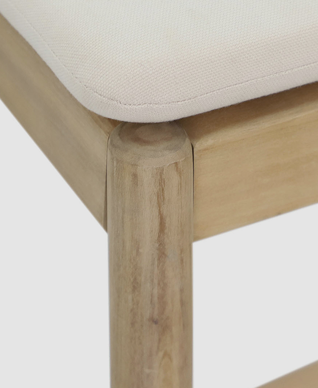 A front corner of the cushion-topped bar stool is zoomed in on to display the natural grain patterns.