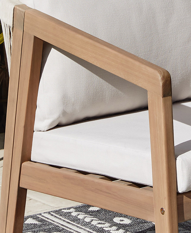 A cropped, three-quarter view of the armchair draws attention to the smoothly-finished tapered eucalyptus wood armrest.