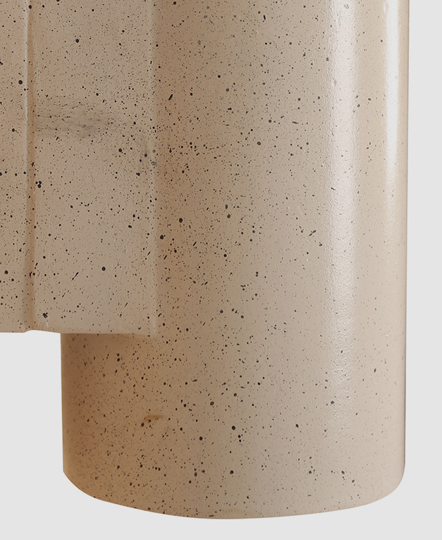 A very close view of the speckled but smooth surface of the wall sconce.