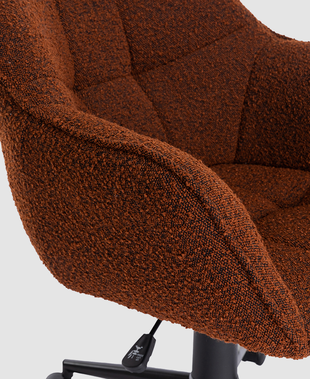 Side view of the terracotta office chair emphasizes the soft, looped texture of the boucle upholstery.