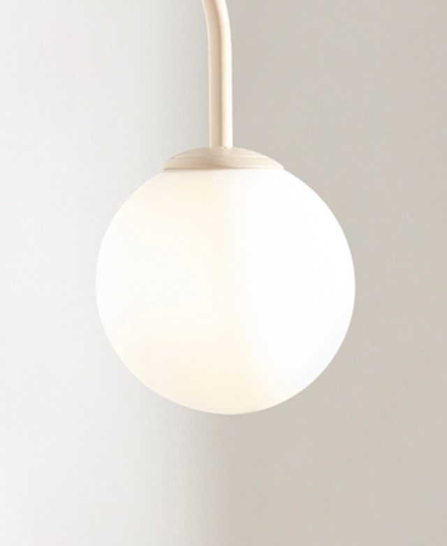 The spherical frosted glass shade diffuses the light of the inner bulb; it's shown against a white background.