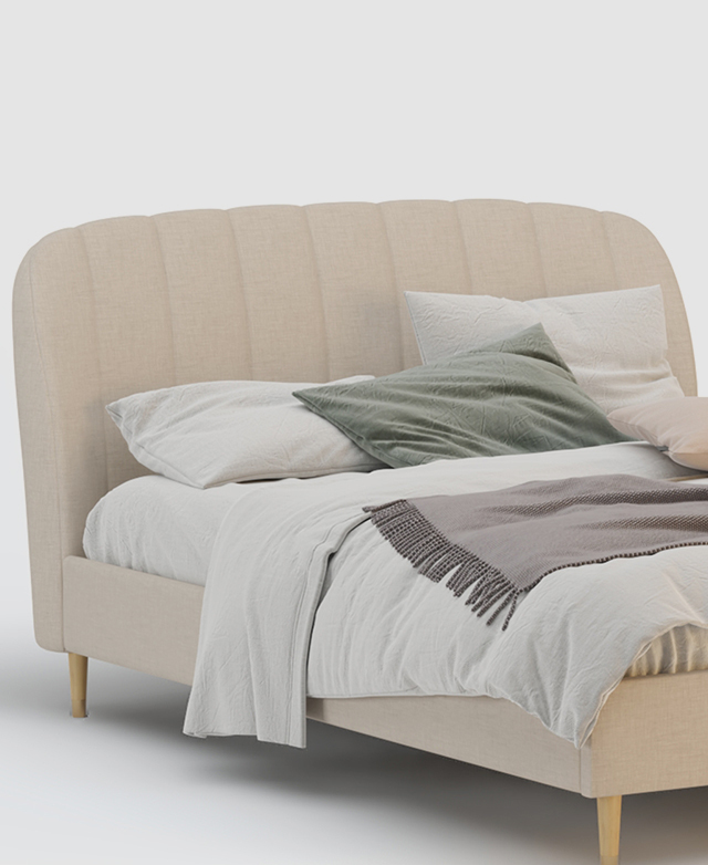 The upholstered bed is dressed with white and soft pastel bedding and cushions.
