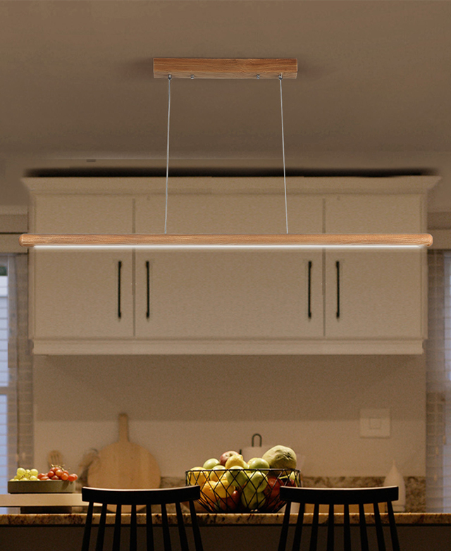The linear light is illuminated over a fruit-topped kitchen bench, creating a warm and homely scene.