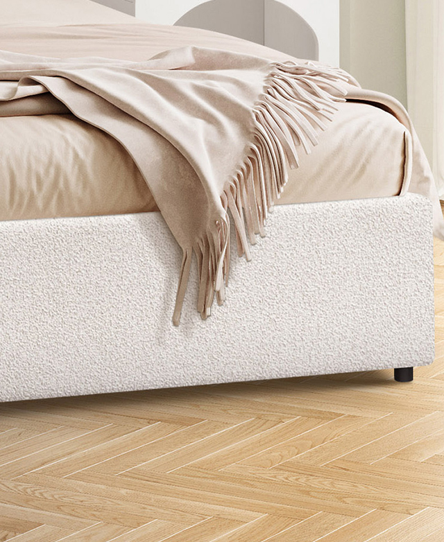 A close view of the boucle bed shows it on parquet flooring, with taupe-coloured bedding. A close view of the boucle bed shows it on parquet flooring, with taupe-coloured bedding.