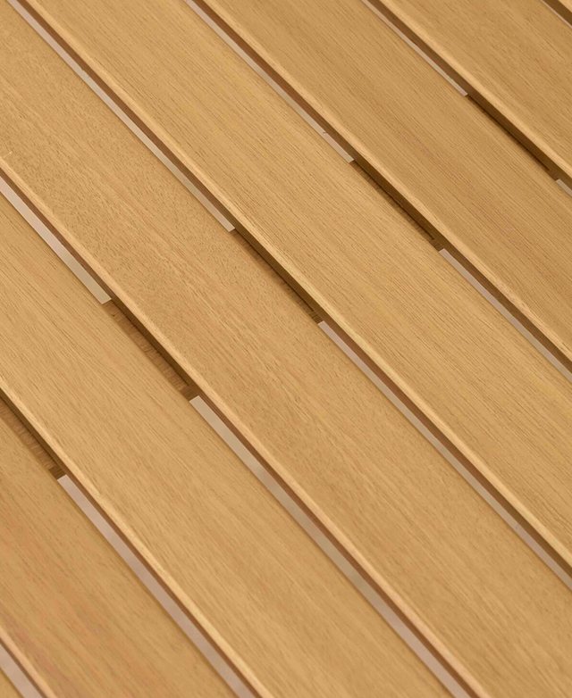 A cropped, bird's eye view of the dining table emphasises the wooden slatted top and its warm hue.