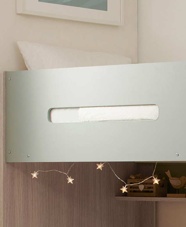 A cropped view of the polyurethane-laminated light green side panel, with white bedding and fairy lights in the frame.