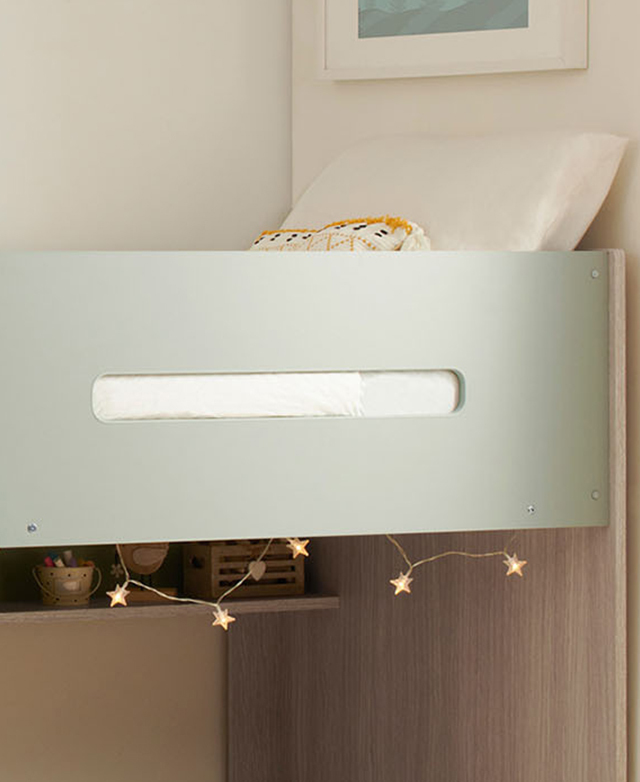 A cropped view of the polyurethane-laminated light green side panel, with white bedding and fairy lights in the frame.