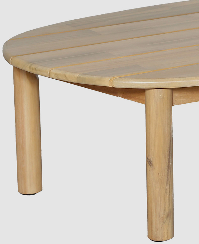 The rounded edges and two of the thick cylindrical legs of the coffee table are in focus.