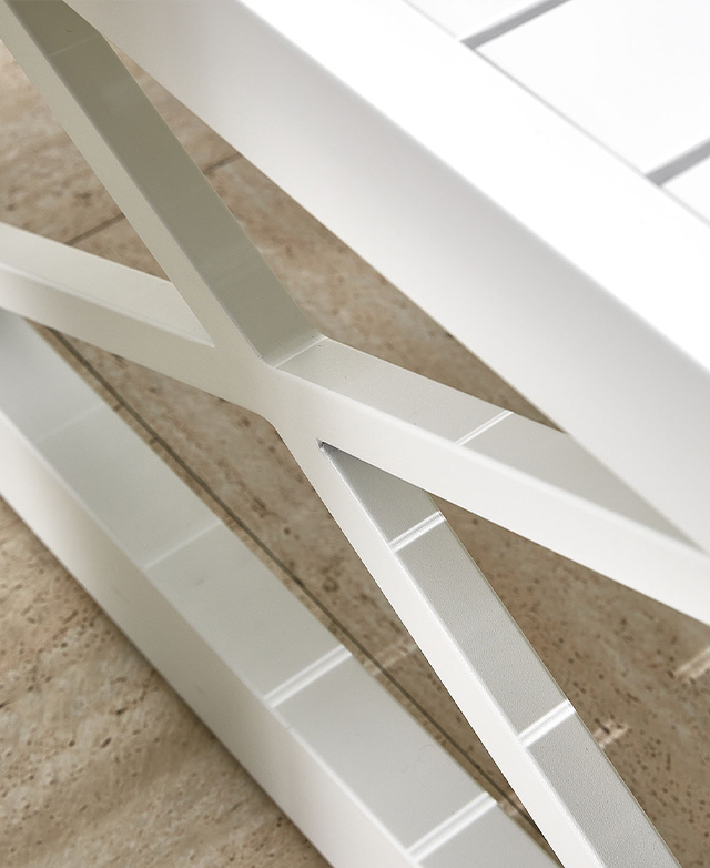 A white metal cross brace at one end of the coffee table.