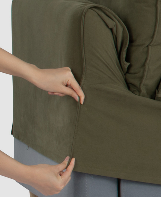 Someone is shown applying the green slip cover to the sofa's frame.