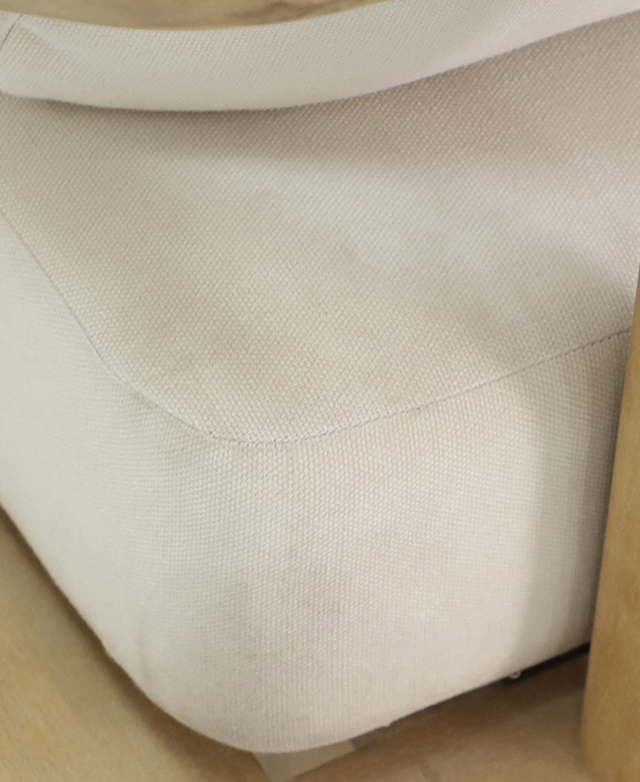 The cream polyester cushion cover tightly encases the thick cushioned seat of the outdoor daybed.