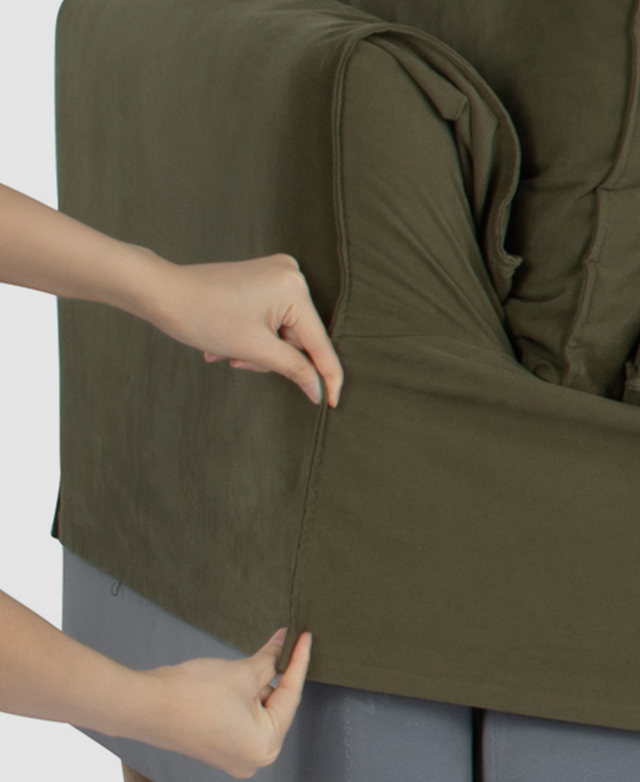 Someone is shown applying the green slip cover to the sofa's frame. Someone is shown applying the green slip cover to the sofa's frame.
