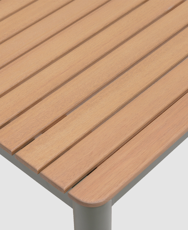 One rounded corner of the wood-top outdoor table is displayed.