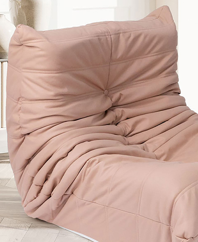 The faux leather pink armless chair has deep pleats and button tufting. The faux leather pink armless chair has deep pleats and button tufting.