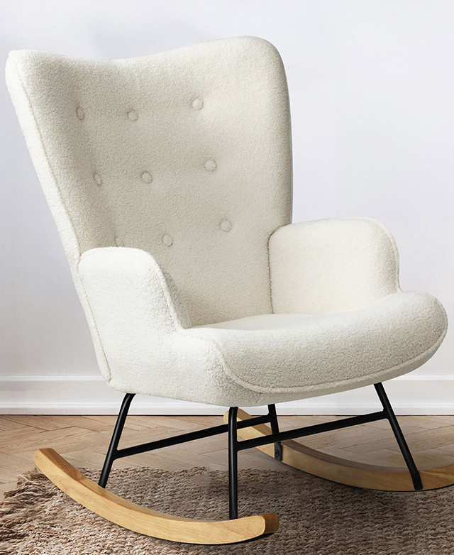 The white boucle rocking chair is in a bright room on a woven jute rug. The white boucle rocking chair is in a bright room on a woven jute rug.