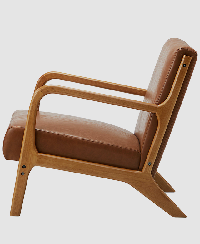 A side view of the tan armchair depicts the sloped seat and its supportive structure.