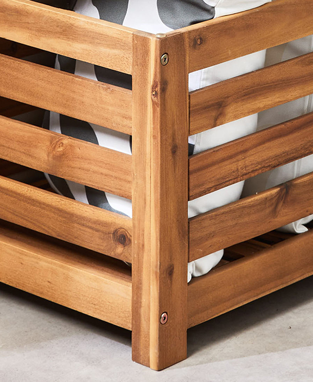 Monochrome cushions are seen through the slatted sides of the timber storage box.