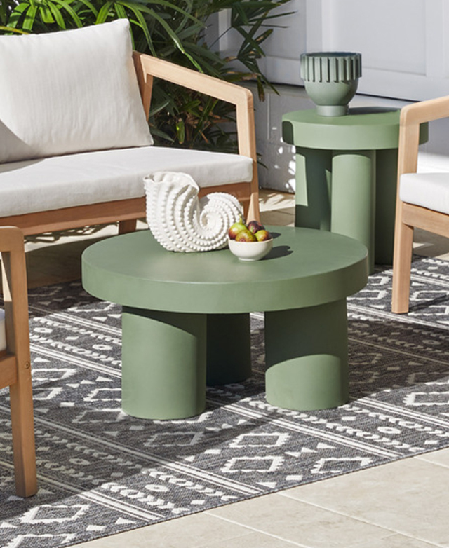 The chunky green coffee table is positioned in the middle of an outdoor lounge setting on top of a grey patterned rug. The chunky green coffee table is positioned in the middle of an outdoor lounge setting on top of a grey patterned rug.