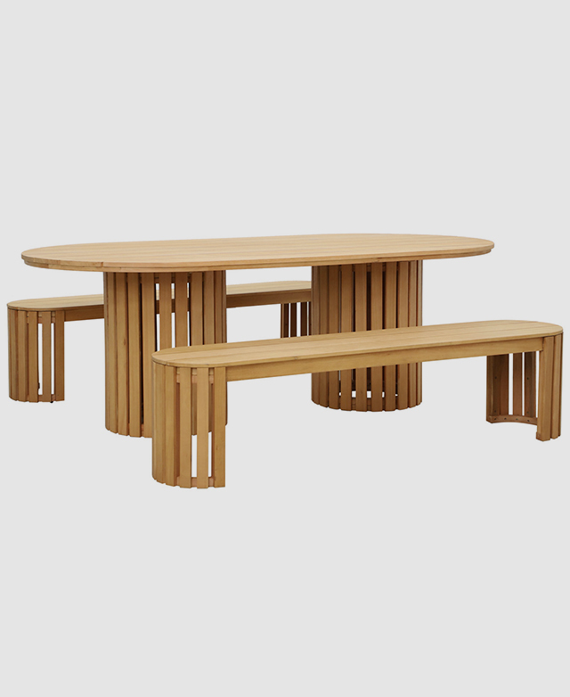 A large, oval dining table and two coordinating benches are made of warm eucalyptus wood.