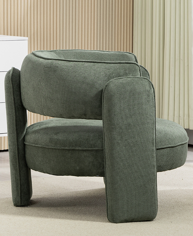 A side view of the green, round armchair highlights its geometry and soft chenille upholstery. A side view of the green, round armchair highlights its geometry and soft chenille upholstery.