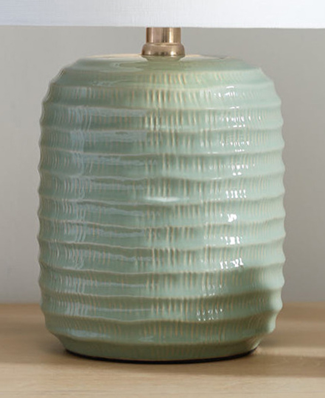 Textured, concentric circles, plus vertical strokes into the ceramic, give the mint green lamp base tactile depth. Textured, concentric circles, plus vertical strokes into the ceramic, give the mint green lamp base tactile depth.