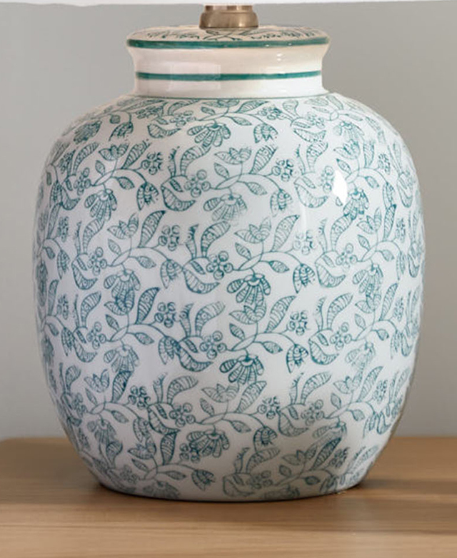 The rounded, green and white floral lamp base has a high-gloss finish. The rounded, green and white floral lamp base has a high-gloss finish.
